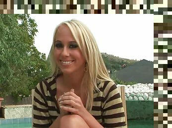 Blonde hottie Carla Cox gives an interview on the poolside