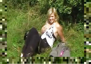 Chubby blonde toys her pussy and gives hand to a guy outdoors