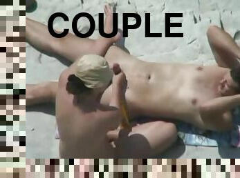 Horny couple stimulate each other's privates on a beach