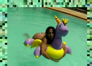 Latina bikini tranny floating in the pool and jerking off