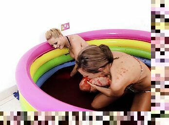 Bikini girls play in a little pool filled with sticky red goo