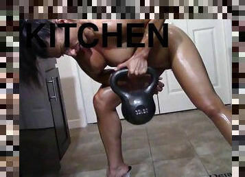 Oiling muscles in her kitchen