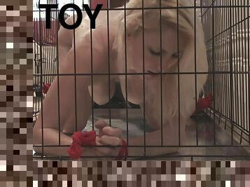 Caged and bound blonde girl takes a toy from her master