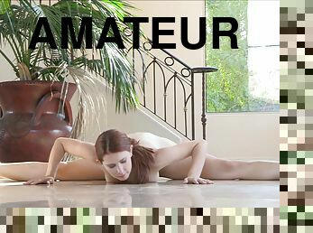 A flexible girl with red hair poses naked in a solo video