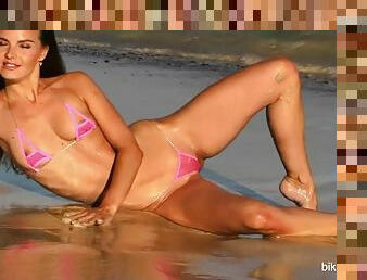 Brunette bikini model poses on the beach