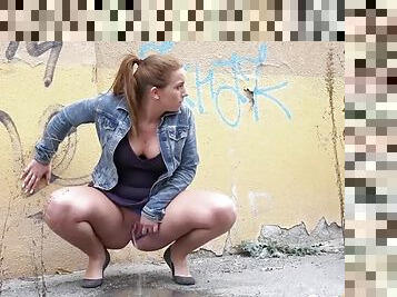 Curvy redhead takes a big piss on the street