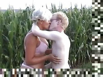 Lustful blond milf has sex with a young dude in a field