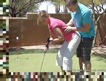 Husband teaches his wife how to golf