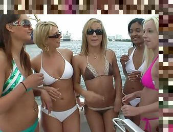 Beautiful lesbians in bikinis kissing on a boat