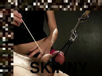 Skinny dominatrix with long dark hair torturing a stranger