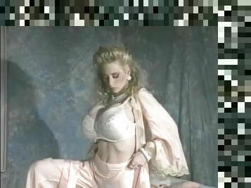 Elegant blonde strips and models her big fake tits