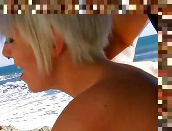 Tattooed German blonde gets her mouth sprayed on the beach