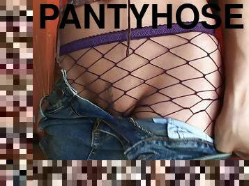 Celeste Star, wearing fishnet pantyhose, fingers her crotch indoors