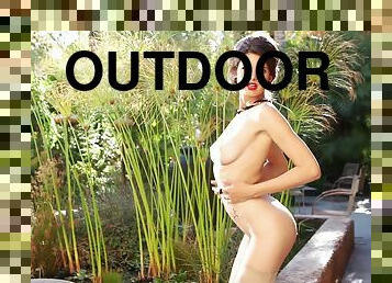 Charming Zoi fondles her tits and shows the ass outdoors