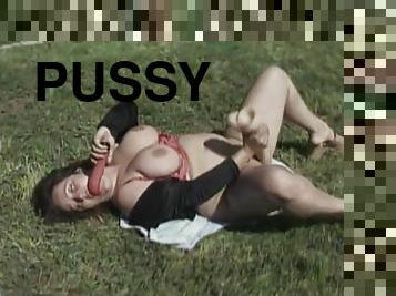 Big-breasted brunette fattie masturbates her pussy in the garden