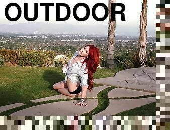 Long-haired redhead babe Elle Alexandra enjoys posing nude outdoors