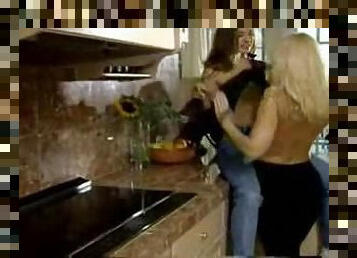 Mature blonde plays lesbian games with a cute teen in the kitchen