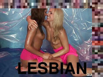 Lesbian coeds oil up a tarp and have fun toying each other