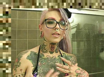 Tattooed alternative chick in a swimsuit talking about her fantasies