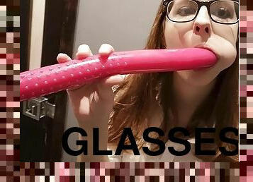 Lady with glasses plays with a dildo.