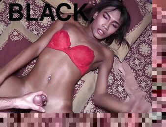 Ladyboy Nutty wears only a red brassiere and black fishnet stockings.