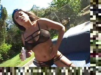 Brunette with fake tits in bra giving dick titjob outdoor