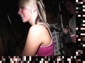 A blonde and a brunette give a blowjob at a party in public