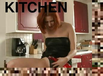 Alluring redhead solo model in thong drilling her pussy using toy in the kitchen
