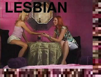 A redhead and a blonde scissor and caress each other in lesbian clip