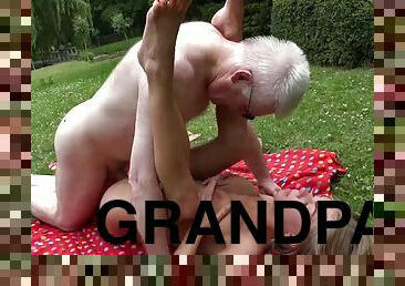 Grandpa lotions up and fucks a bikini girl in the grass