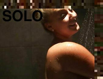 A chubby blonde with monster tits takes a hot shower