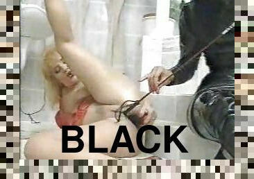 Dominatrix in black pisses on her submissive girl