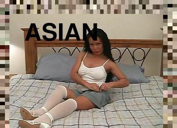 Sexy Asian milf in white stockings and high heels masturbates