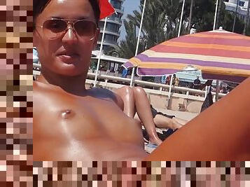 Small tits girl with a great tan is topless at the beach