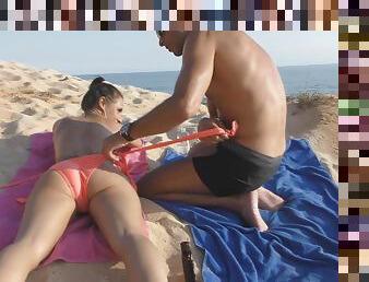 Dude oils up gorgeous Jess and massages her body on the beach