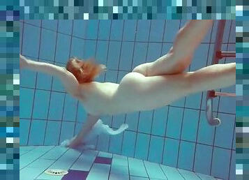 Redhead goes for a nude swim in the pool