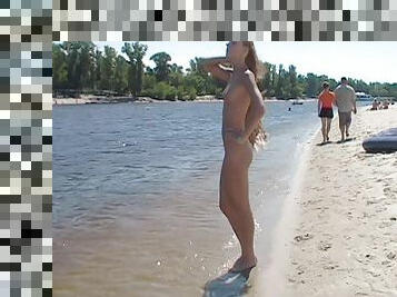 Watch a naked chick at the beach tan her hot body