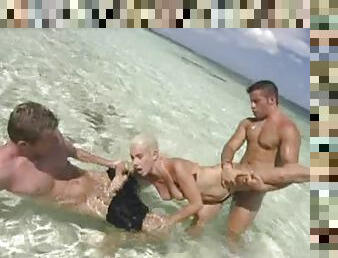 Horny blonde babe having sex on the beach with two men