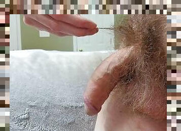 Hairy guy playing with his big cock on the edge of bed