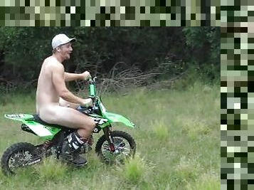 Naked man riding a Dirt bike