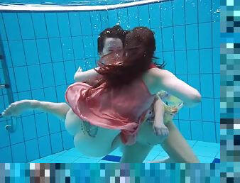 Two saucy lassies remove their clothes under the water