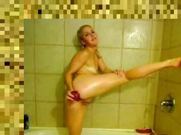 A pretty flexible blonde slams her asshole with a dildo in the bathroom