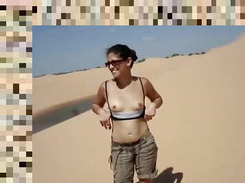 Naughty brunette chick flashing her tits in desert