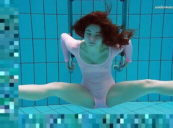 Russian redhead slowly strips down in the swimming pool