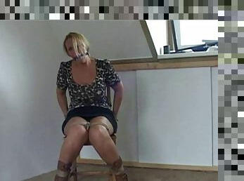 Busty honey Deedee is topless, tied up and ballgagged on a chair