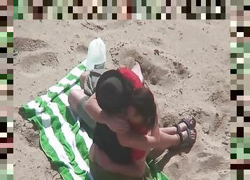 Kissing and tit sucking on the beach with a couple