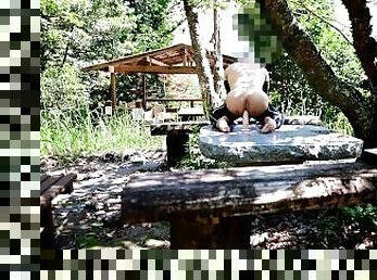 Anal masturbation on a table in the park.