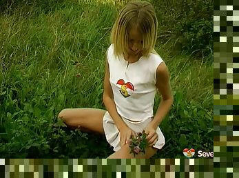 Pleated skirt teen slides a toy into her pussy in the grass